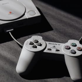 photo of play station game console and remote controller